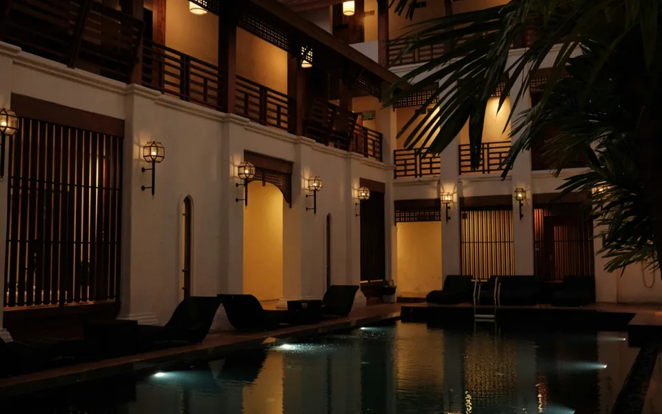 Hotel pool and lit balconies at night in Chiang Mai
