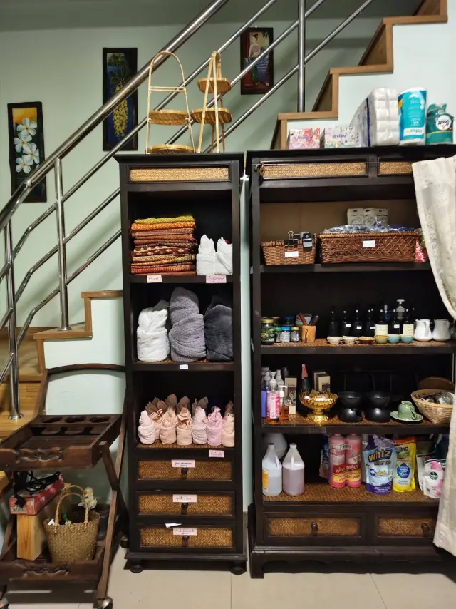 Shelves of towels, oils and spa products beneath the staircase at Ai Oon Massage Lanna