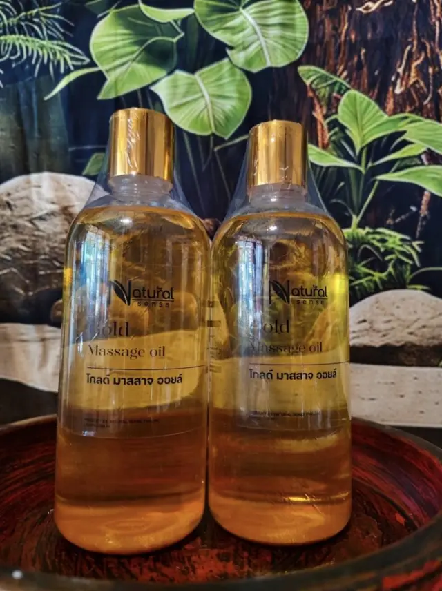 Two bottles of gold massage oil displayed on a tray at Ai Oon Massage Lanna